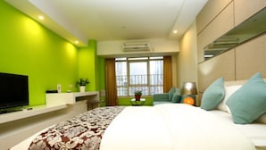 A modern hotel room with a large bed, a TV, a desk, and a window with a city view. - F&H Apartment Guangzhou Wales Branch (Guangzhou)