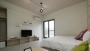 A modern bedroom with a large bed, a television, and a window. - Happiness 210 (Dongshan)