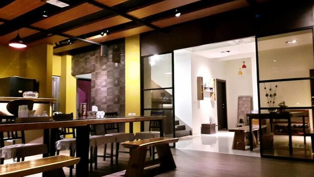 A restaurant with wooden tables and benches, a stone wall, and a modern interior design. - Happiness 210 (Dongshan)
