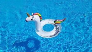 En klar, blå pool med en enhjørning-flyder.