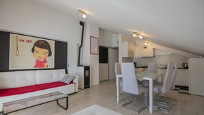 A modern living room with a white sofa, a glass coffee table, and a dining area with a white table and chairs. - Villa Marchelina Grubine - Beautiful stone villa with 2 pools (Grubine)