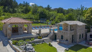 A stone building with a swimming pool, outdoor seating, and a well-maintained lawn. - Villa Marchelina Grubine - Beautiful stone villa with 2 pools (Grubine)