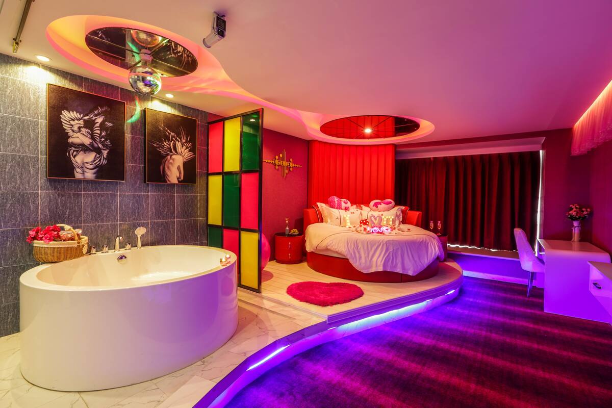 A modern bathroom with a freestanding bathtub, a vanity, and a mirror.