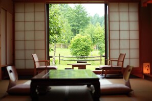 Et traditionelt japansk rum med tatami-gulv, et lavt bord og to stole.