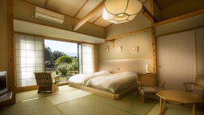Une chambre de style japonais traditionnel, avec un sol recouvert de tatamis, un lit bas, une télévision et une vue sur un jardin.
