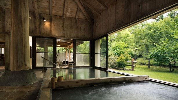 Un espace de bien-être avec un décor intérieur en bois, une grande fenêtre et une vue sur l’extérieur.