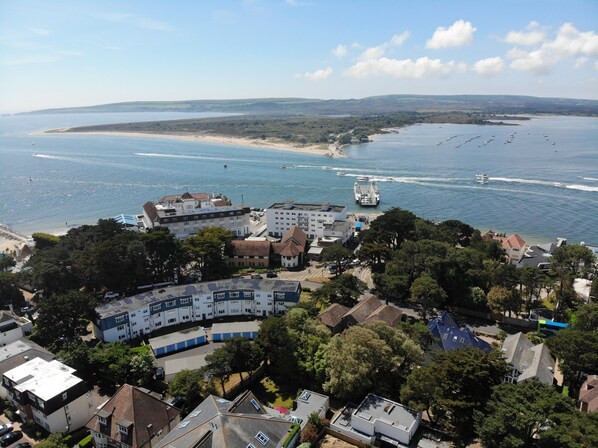 Une ville côtière dotée d’un port de plaisance, de bâtiments aux toits plats et d’une plage en arrière-plan.