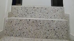 A staircase with granite steps leading to a door.