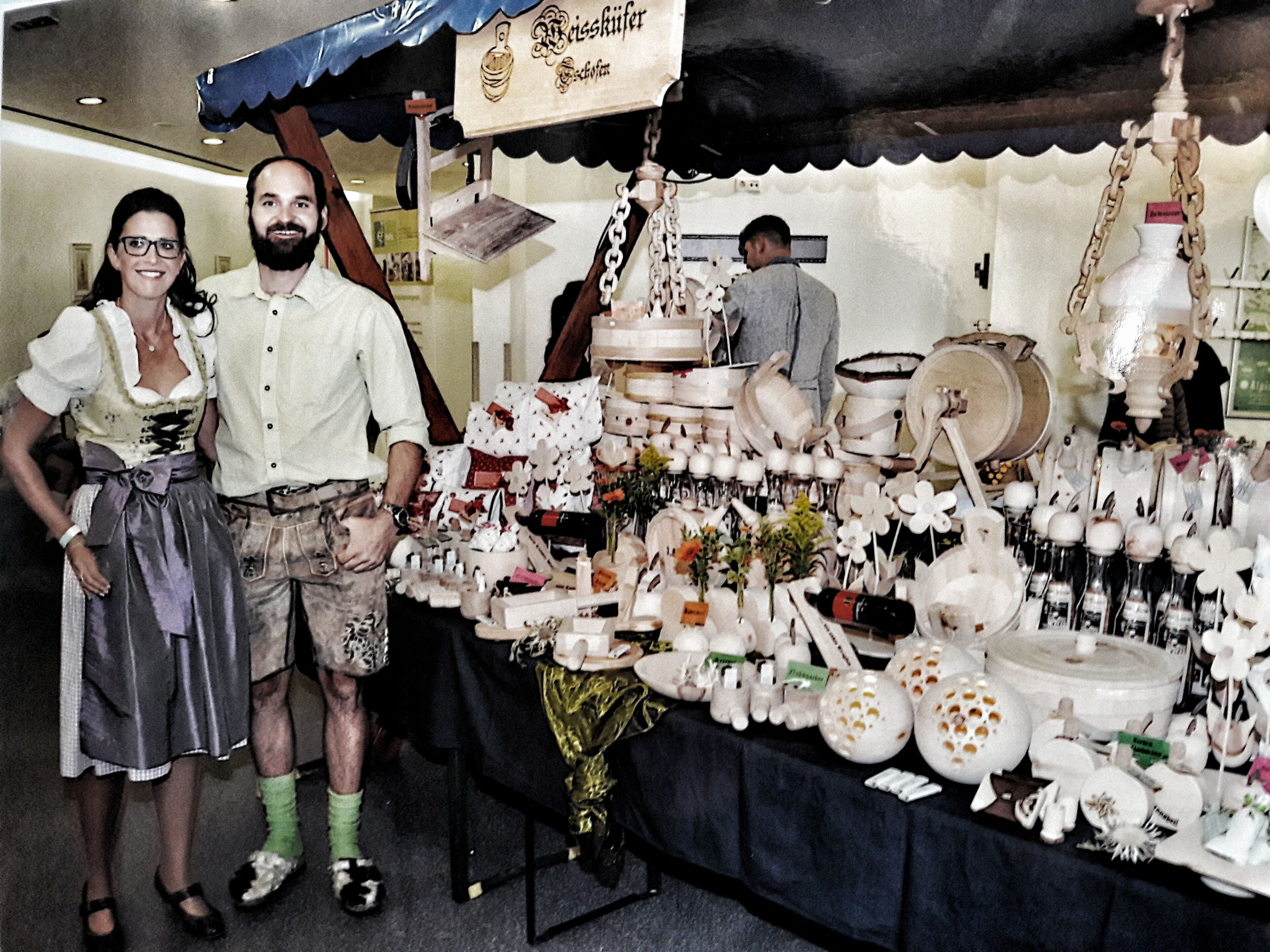 A table with various ceramic items and a person in traditional attire.