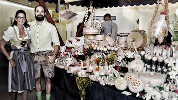 A table with various ceramic items and a person in traditional attire.
