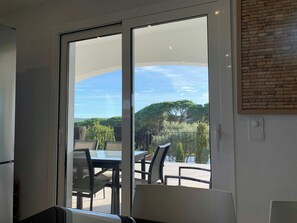 A room with a sliding glass door leading to an outdoor patio with a table and chairs.