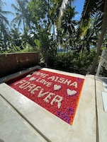 Un parterre rectangular con las palabras "LOVE ALWAYS" y dos corazones hechos de flores.