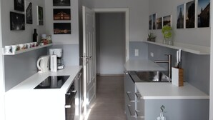 Een moderne keuken met witte kasten, roestvrijstalen apparatuur en een centraal eiland.