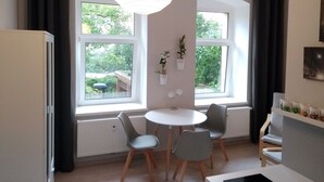 Een moderne keuken met een eethoek, grote ramen en planten in potten.