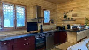 Une cuisine moderne avec des murs en bois, des appareils électroménagers en acier inoxydable et un four encastré.