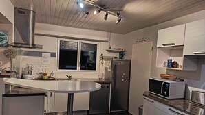 Eine moderne Küche mit einem Edelstahl-Kühlschrank, einer Mikrowelle und einem Spülbecken.