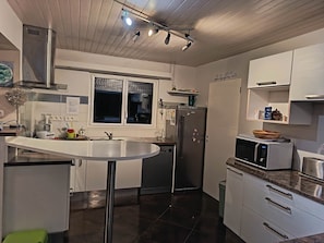A modern kitchen with a stainless steel refrigerator, a microwave, and a sink.