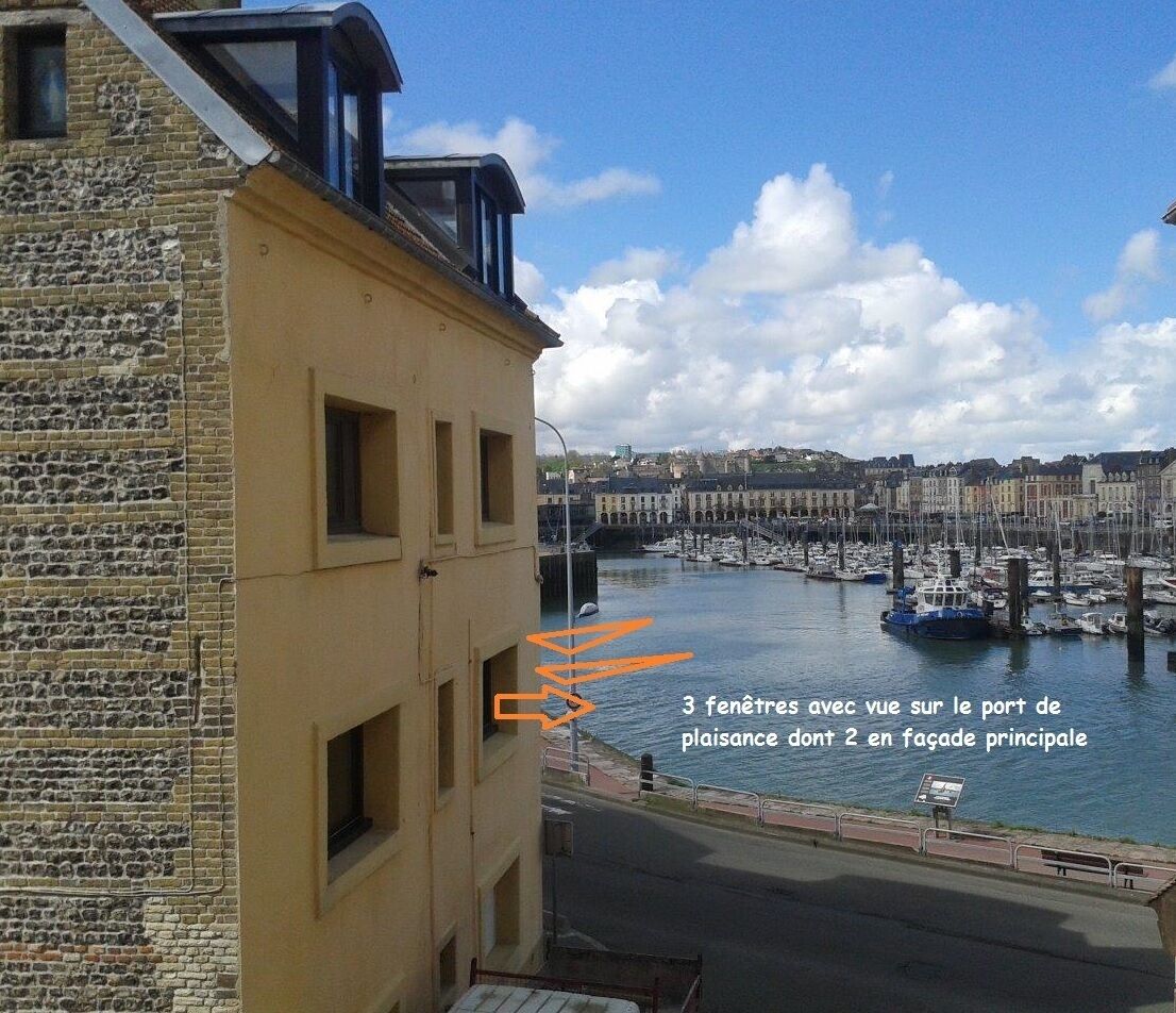 Un bâtiment doté de trois fenêtres donnant sur une marina.