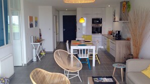 A modern apartment with a dining area, kitchen, and living space.