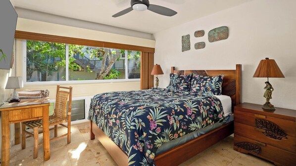 Une chambre à coucher comprenant un lit, des tables de chevet, un bureau et une chaise.