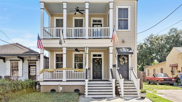 Une maison à deux étages avec un porche à l’avant, un balcon et un garage.
