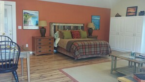 A bedroom with a bed, a dresser, a chair, a table, and a wardrobe. - Beautiful Mountain Getaway - All Four Breathtaking Seasons! (Hendersonville)