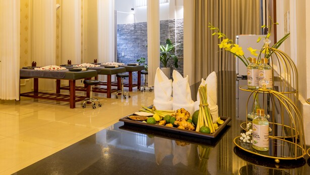 Une salle de spa équipée d’une table de massage, d’un plateau d’herbes aromatiques et d ’une composition florale décorative.