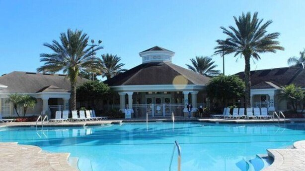 A swimming pool with lounge chairs and palm trees. - Windsor Palm Resort/Pool /3 miles to Disney (Kissimmee)