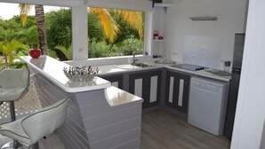 A compact kitchen with a built-in island, a sink, and a dishwasher. - Guest-House In A Palmgrove For A Couple. Space, Privacy And Silence (Saint Martin)