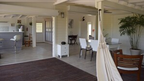 A spacious living area with a wooden floor, white furniture, and a large potted plant. - Guest-House In A Palmgrove For A Couple. Space, Privacy And Silence (Saint Martin)