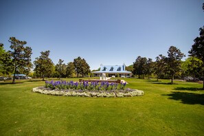 A large house with a blue roof and a fountain in the front lawn.