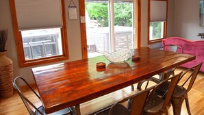 A wooden dining table with chairs, a glass bowl, and a woven basket.