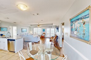 Relax in this open-plan living space with a central seating area, comfortable sofa, and dining table.