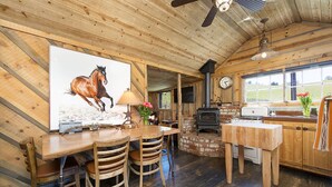 Un intérieur rustique en bois, comprenant un coin repas, une cheminée et une cuisine.