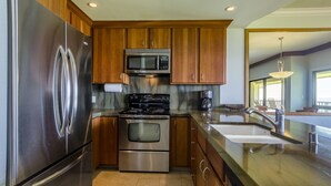 Una cocina moderna con electrodomésticos de acero inoxidable, armarios de madera y una isla grande con fregadero.