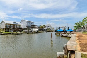 Waterfront property with a wooden pier and multi-story buildings featuring balconies.
