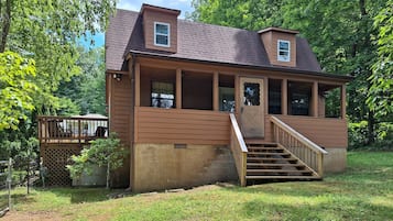 Set amidst lush greenery, this charming home features a spacious porch and a welcoming entrance.