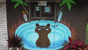 A door with a mural of a hippopotamus, two palm trees, and a sign for Hippo Head Hotel.