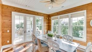 A spacious dining area with a wooden ceiling, large windows, and a ceiling fan. - 24 Dene Court Beautiful  8 Bedroom Home in DeBordieu, Private Pool! (Georgetown)