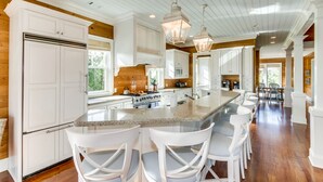 A spacious kitchen with a large island, white cabinetry, and a wooden ceiling. - 24 Dene Court Beautiful  8 Bedroom Home in DeBordieu, Private Pool! (Georgetown)