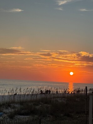 A sunset over a beach with a fence in the foreground. - 10% OFF BEACH FRONT COTTAGE! C 30A BIKE/SHOP/RESTAURANTS (Panama City Beach)