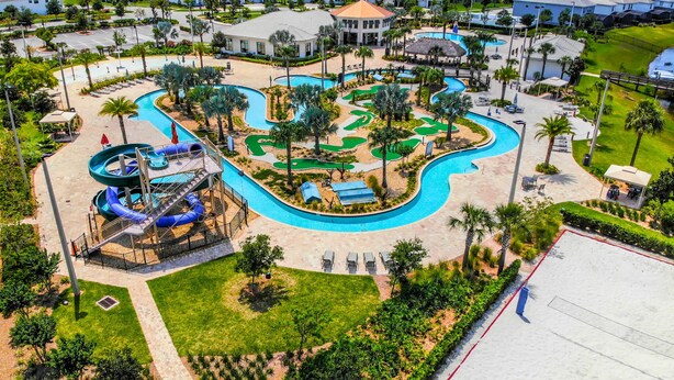 A resort with a large pool area, a water slide, and a golf course. - Family Fun: Condo near Theme Parks & Pools! (Kissimmee)