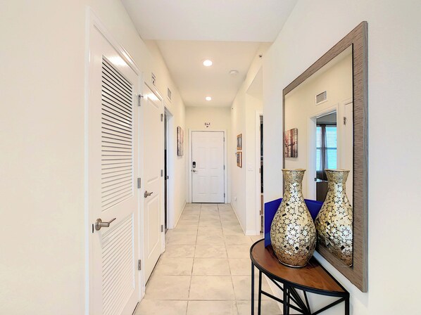 A hallway with a door marked 'EXIT' and two decorative vases on a table.