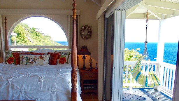 A bedroom with a four-poster bed, a view of the ocean, and a balcony with a hammock. - Ocean View Villa & Cottage located 5 min Drivefrom Megans Bay with Cocktail Pool (St Thomas)