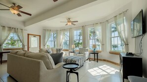 A spacious living room with a sofa, armchairs, a coffee table, and a TV. - Large Ocean Front Condo - 2 bedroom/2.5 bathroom - Gold Standard Approved (San Pedro)