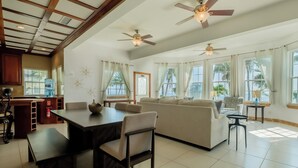 A spacious living area with a dining table, sofa, and ceiling fans. - Large Ocean Front Condo - 2 bedroom/2.5 bathroom - Gold Standard Approved (San Pedro)