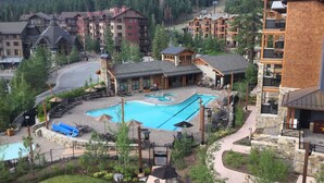 A resort with multiple buildings, a central pool area, and surrounding greenery.