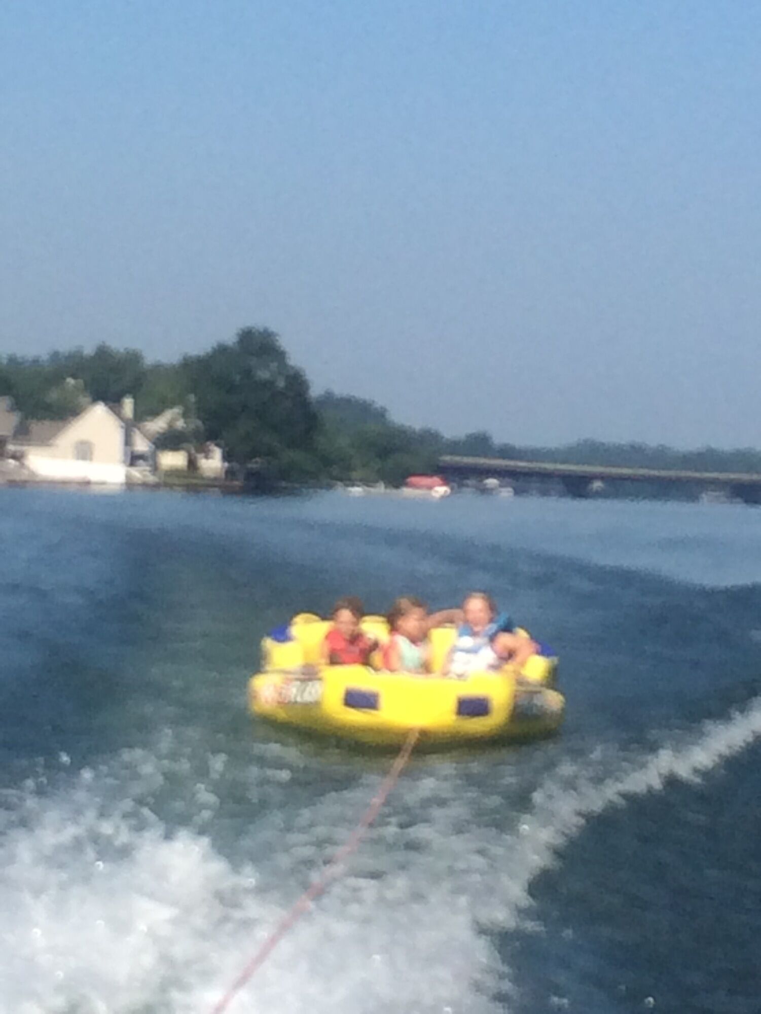 Un groupe de personnes se trouve sur une sorte de radeau jaune flottant sur l’eau.