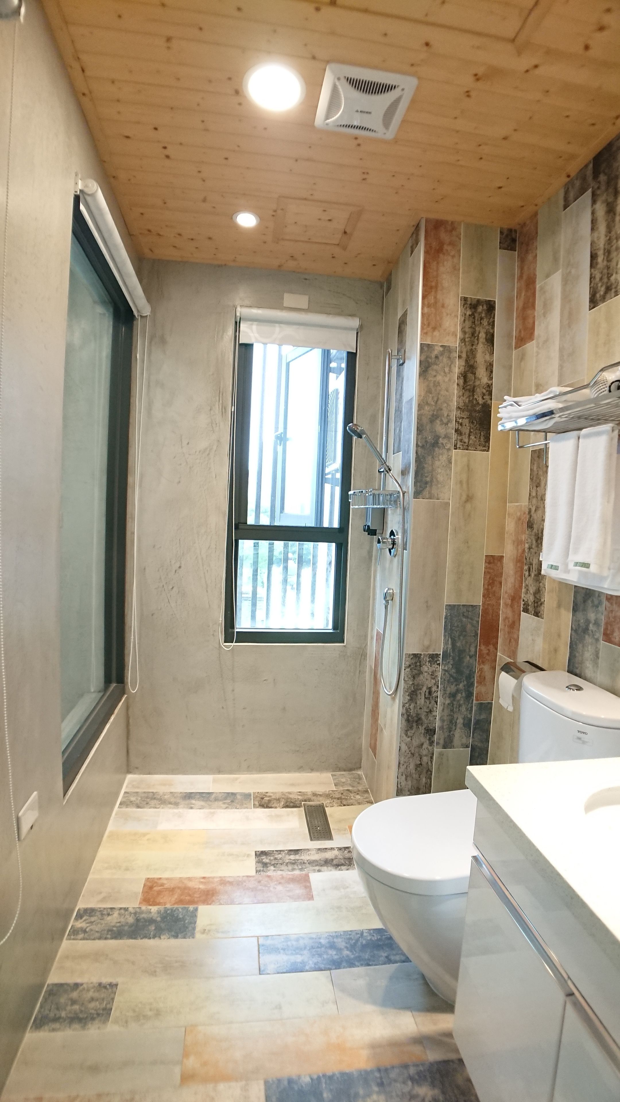 A modern bathroom with a shower, toilet, and sink.
