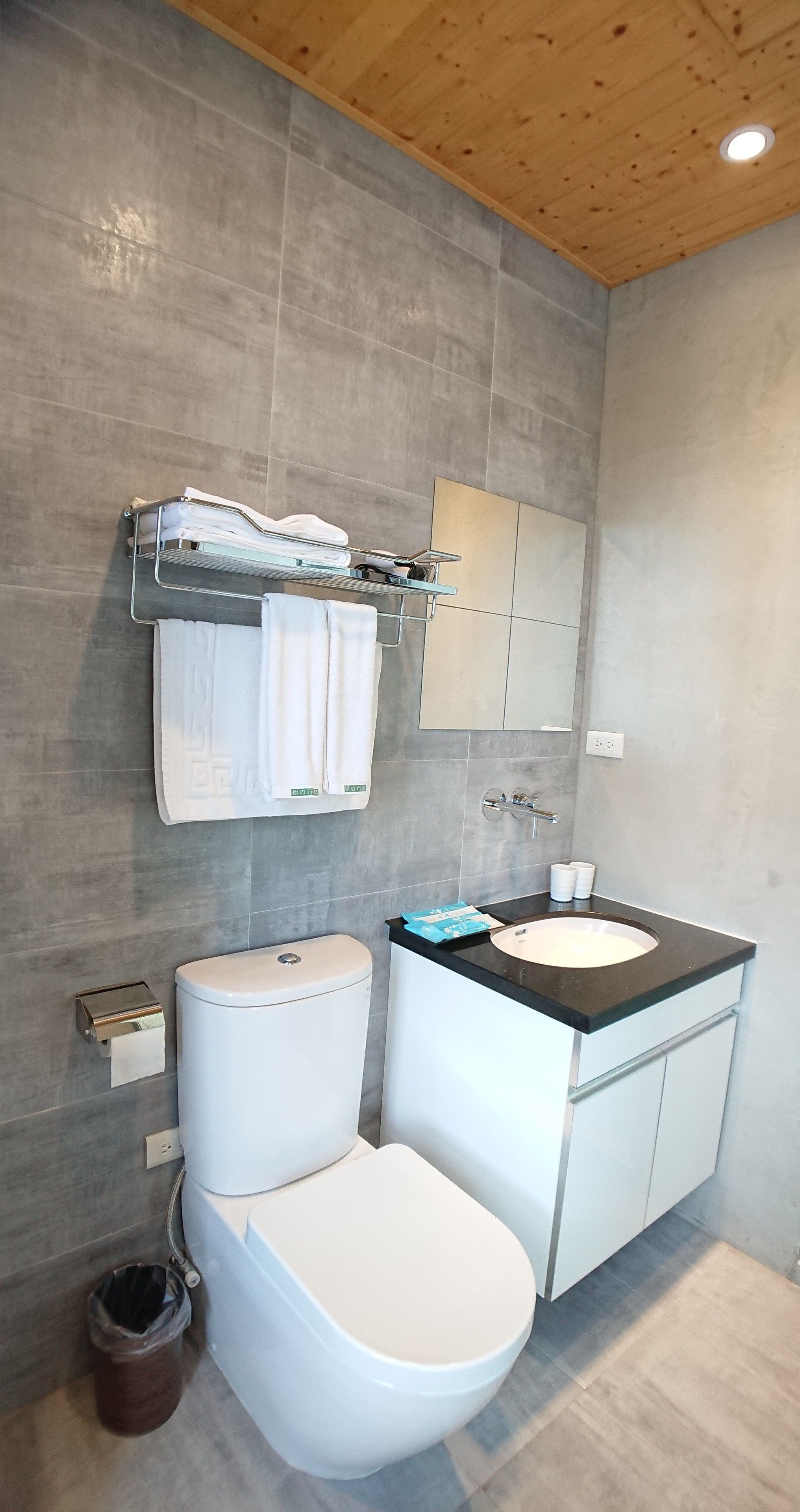 Ein modernes Badezimmer mit Toilette, Waschbecken und Spiegel.